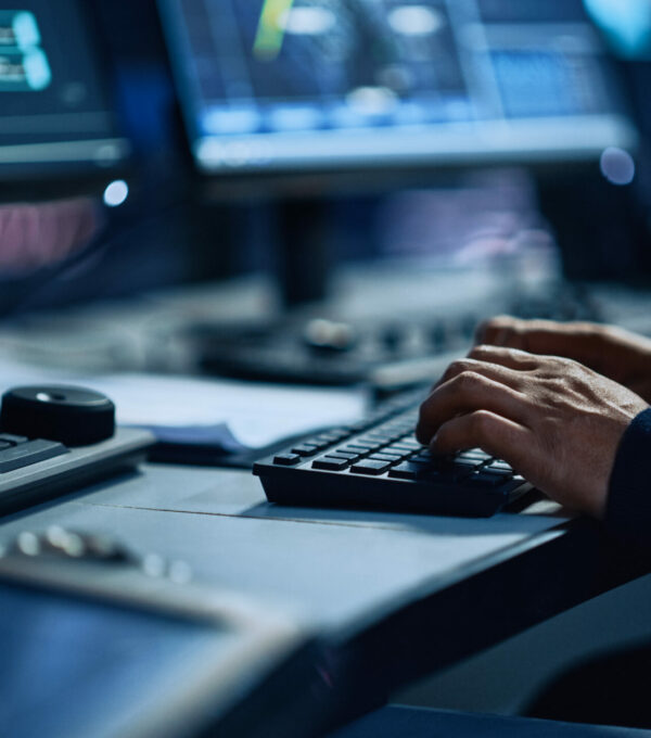 Close Up of a Professional Office Specialist Working on Desktop Computer in Modern Technological Monitoring Control Room with Digital Screens. Manager Typing on keyboard and Using Mouse.