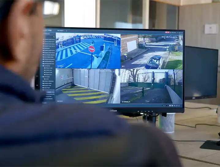 Agent de sécurité observant plusieurs flux vidéo de caméras de surveillance sur un écran de contrôle