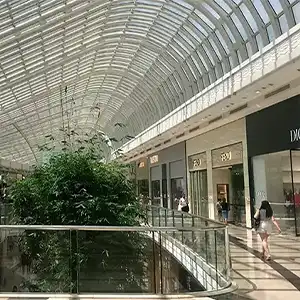 Galerie marchande moderne avec verrière et végétation intérieure