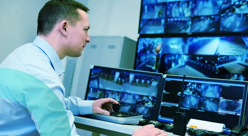 Un agent de contrôle devant des écrans qui assure une supervision 24h/24, 7J/7